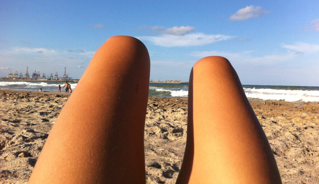chica tomando el sol en la playa un día de verano
